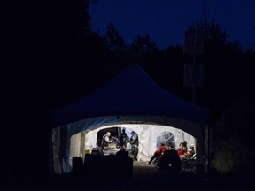 This file photo taken on Aug. 5, 2017 shows refugees who crossed the Canada/U.S. border illegally near Hemmingford, Quebec being processed in a tent after being arrested by the RCMP.