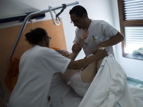 Nurses take care of an elderly patient at the palliative care unit of a French hospital. Most of us would prefer to die at home, surrounded by loved ones.