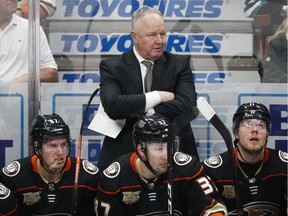 FILE - In a Wednesday, Jan. 23, 2019 file photo, Anaheim Ducks coach Randy Carlyle, center, watches during the third period of the team's NHL hockey game against the St. Louis Blues, in Anaheim, Calif. The Anaheim Ducks have fired coach Randy Carlyle amid a seven-game losing streak. The Ducks announced Sunday, Feb. 10, 2019  that general manager Bob Murray would take over as interim coach for the remainder of the regular season.