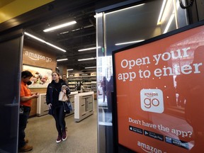FILE- In this Jan. 22, 2018, file photo, a shopper departs an Amazon Go store in Seattle. Get ready to say good riddance to the checkout line. A year after Amazon opened its first cashier-less store, startups and retailers are racing to get similar technology in other stores throughout the world, letting shoppers buy groceries without waiting in line.