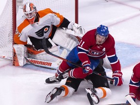 Montreal Canadiens' Brendan Gallagher falls over Philadelphia Flyers defenceman Robert Hagg in front of goaltender Brian Elliott during third period NHL hockey action in Montreal on Thursday, Feb. 21, 2019.