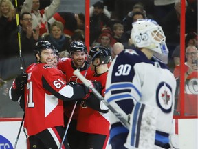 The Ottawa Senators' Mark Stone (61) celebrates his goal with teammates Ben Harpur (67) and Mark Borowiecki (74) to the side of Winnipeg Jets goaltender Laurent Brossoit during the first period at the CTC on Saturday, Feb. 9, 2019.