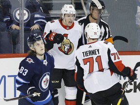 The Ottawa Senators' Ryan Dzingel (18) and Chris Tierney (71) celebrate Dzingel's game-winning overtime goal against the Winnipeg Jets as Sami Niku (83) skates by in Winnipeg on Saturday, Feb. 16, 2019.