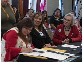 Carolyn Bennett (right), minister of Crown Indigenous Relations, and Francyne Joe (centre), president of the Native Women's Association of Canada, look on as Viviane Michel (left) of the Quebec Indigenous Women's Association takes part in a signing ceremony in Ottawa on Friday, Feb.1, 2019, to ensure the organization can fully participate in efforts to address issues — including those related to Indigenous health, housing and education.