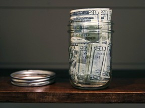FILE - In this June 15, 2018, file photo a canning jar filled with currency sits on a shelf in East Derry, N.H. An emergency fund doesn't have to be wishful thinking when you're building your financial life. Start small to build a habit, use windfalls to kick-start your fund and have a plan for irregular expenses.