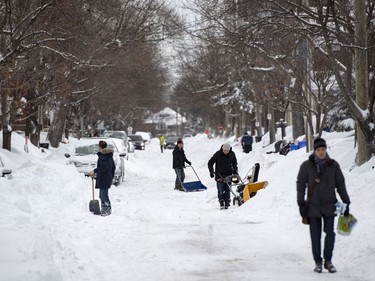People dig out their cars and driveways in Ottawa's Glebe neighbourhood during a winter storm on Wednesday, Feb. 13, 2019. The storm, which began on Tuesday afternoon, is expected to bring 30-40 centimetres of snow by Wednesday. All Ottawa-area schools are closed and classes were cancelled for a 24 hour period at the University of Ottawa and Carleton University.
