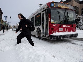 A man crosses a snowbank after getting off an OC Transpo bus.