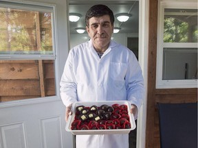 Assam Hadhad, a Syrian refugee who arrived in Canada last year, displays a tray of chocolates at his shop, Peace by Chocolate, in Antigonish, N.S. on September 21, 2016. The one-time Syrian refugee who founded a thriving Nova Scotia chocolate company has announced plans to hire and mentor other refugees. Peace by Chocolate of Antigonish, N.S., has committed to hiring 50 refugees by 2022, and to mentor 10 refugee-run start-ups over the next few years.