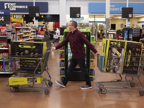 Juston Herbert pushes two carts of Morf Boards, a popular kids toy, through a Walmart in Phoenix.