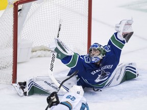 The Sharks' Kevin Labanc, bottom, scores a goal in the second period of Monday's game despite a spectacular stretch by Canucks netminder Michael DiPietro. DiPietro was recently called up from the OHL's Ottawa 67's because injuries left the NHL Canucks short of goaltenders.