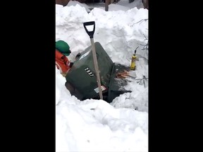 Ottawa Hydro technician working on faulty transformer in a massive snowpit in Kanata.