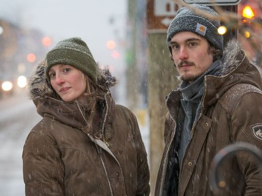 Olivia Richardson and Mitchell Sawyer wait for a bus on Bank Street in the early stages of Tuesday's storm.