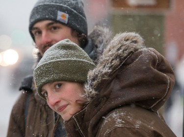 Olivia Richardson and Mitchell Sawyer wait for a bus on Bank Street as Tuesday's storm begins.