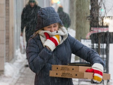 A woman covers her face while walking along Bank Street on Tuesday.