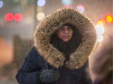 This pedestrian stays warm under her hood while walking along Bank Street at Gilmour as the storm starts to rage on Tuesday.