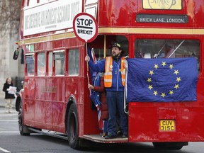 Anti-Brexit protesters on board a hired red London bus demonstrate as they drive past the Houses of Parliament in London, Monday, Jan. 28, 2019.