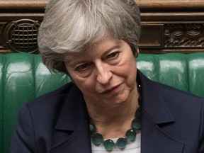 A handout photograph released by the UK Parliament on March 13, 2019 shows Britain's Prime Minister Theresa May reacting on the front bench in the House of Commons in London on March 13, 2019 during the proceedings in which MPs voted to reject leaving the EU without a deal.