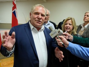 Ontario Premier Doug Ford gestures as he speaks to reporters in Mildmay on Wednesday evening. To the right is Huron-Bruce MPP and Education Minister Lisa Thompson.