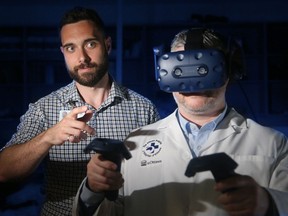 Medical physicist Justin Sutherland, left, explains the virtual reality technology as neurosurgeon Dr. Adam Sachs virtually pokes around inside someone's brain at The Ottawa Hospital's General campus Monday, March 18, 2019.