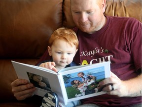 Jordan MacWilliam looks at a book of memories of his wife Kayla, with his son Leighton. Kayla, died last September of cancer. She was 27 and had just given birth to their only son