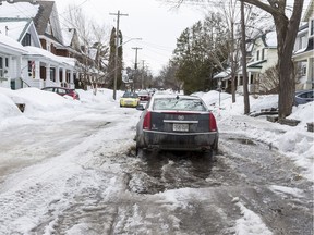 A car navigates along a flooded Belmont Avenue in Ottawa on March 11, 2019.