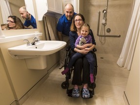 Jennifer and Eli Glanz with daughter Emilia in the master bathroom they had modified to accommodate Jenifer's wheelchair.