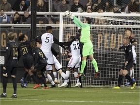 Birmingham Legion FC goalkeeper Matt Van Oekel leaps over Ottawa Fury FC's Jamar Dixon (22) to pull in a corner kick attempt during a United Soccer League match at Birmingham, Ala., on Saturday, March 16, 2019. Fury FC won the contest 1-0.