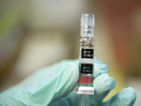 A nurse holds a vaccine shot.