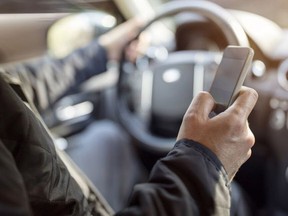 A stock photo of a driver sending a text message.