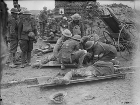 Dressing wounded Canadians during advance to Hill 70. August, 1917.