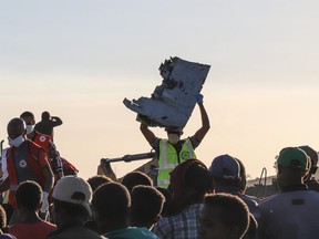 A man carries a piece of debris on his head at the crash site of a Nairobi-bound Ethiopian Airlines flight on March 10, 2019.
