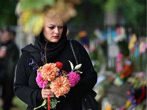 A woman prepares to leave flowers in tribute to victims in Christchurch on March 17, 2019, two days after a shooting incident at two mosques in the city.