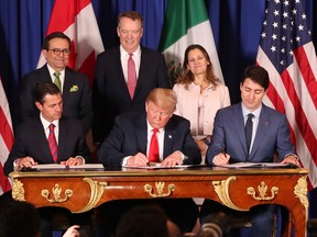 Prime Minister Justin Trudeau, right, President Donald Trump, centre, and Mexico's President Enrique Pena Nieto sign a new United States-Mexico-Canada Agreement that is replacing the NAFTA trade deal.