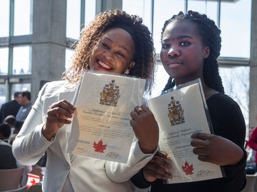 Nadege Glasse (L) and Victoire Elisee Glasse show off their citizenship document as the Institute for Canadian Citizenship, together with Immigration, Refugees and Citizenship Canada, and the National Gallery of Canada, held a special community citizenship ceremony in the Great Hall at the National Gallery of Canada.