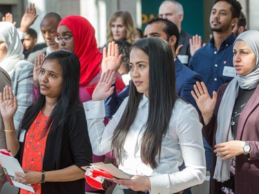 New Canadians, including Raisa Punzalan, (C), swear allegiance as the Institute for Canadian Citizenship, together with Immigration, Refugees and Citizenship Canada, and the National Gallery of Canada, held a special community citizenship ceremony in the Great Hall at the National Gallery of Canada
