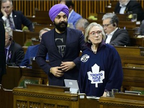Innovation, Science and Economic Development Minister Navdeep Bains and Indigenous and Northern Affairs Minister Carolyn Bennett rise to vote during a marathon voting session in the House of Commons on Parliament Hill in Ottawa on Thursday, March 21, 2019.