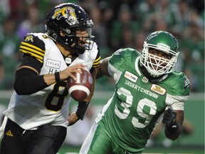 Hamilton Tiger-Cats quarterback Jeremiah Masoli is chased by Saskatchewan Roughriders defensive lineman Charleston Hughes in July 2018. The CFL will consider another rule change to further protect the QBs.