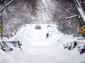 The Quebec government has agreed to compensate motorists who were trapped for hours on a major Montreal highway in March 2017 following a massive snowstorm. A woman shovels snow from around her car following a winter storm in Montreal, Wednesday, March 15, 2017.