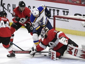 Ottawa Senators goaltender Anders Nilsson (31) tries to keep the puck from St. Louis Blues centre Robert Thomas (18) as Senators defenceman Cody Goloubef (28) and centre Jean-Gabriel Pageau (44) defend during the first period at the CTC on Thursday, March 14, 2019.