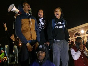 In this Nov. 24, 2014 file photo, Ferguson activist Daren Seals, top centre, awaits the decision by a grand jury on whether to indict Darren Wilson in the death of Michael Brown in front of the police station in Ferguson , Mo.