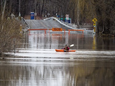 A kayaker played in the current on what normally would be the road into Petrie Island Sunday evening.