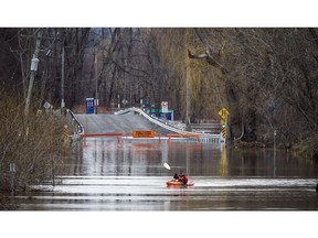 The low lying areas around Ottawa and Gatineau were hit with the beginning of the flooding near the rivers, Sunday, April 21, 2019. A paddler played in the current on what normally would be the road into Petrie Island Sunday evening.   Ashley Fraser/Postmedia