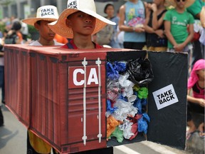 Filipino environmental activists wear a mock container vans filled with garbage to symbolize the 50 containers of waste that were shipped from Canada to the Philippines two years ago, as they hold a protest outside the Canadian embassy at the financial district of Makati, south of Manila, Philippines on May 7, 2015. The president of the Philippines says if Canada doesn't take back its trash within the next week he will 'declare war' and ship the containers back himself. Filipino media outlets are reporting that Rodrigo Duterte made comments Tuesday about dozens of shipping containers filled with Canadian household and electronic garbage that have been rotting in a port near Manila for nearly six years.