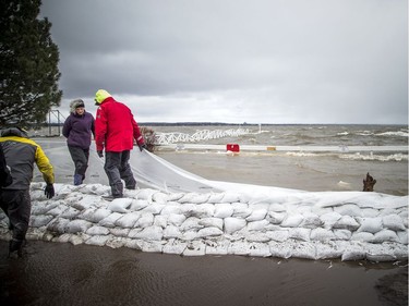 People were building a wall of sandbags and plastic to try to hold back the Ottawa River near the Britannia Yacht Club Saturday,