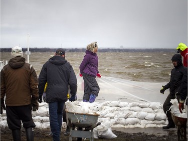 People were building a wall of sandbags and plastic to try to hold back the Ottawa River near the Britannia Yacht Club Saturday,