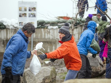 Volunteers work together to sandbag along the Ottawa River near Jamieson and Kehoe Streets in the Britannia area, Saturday, April 27, 2019.