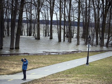 A man stands in Parc des Cèdres to take a photo as the Ottawa River shows high levels of flooding Saturday, April 27, 2019, in Aylmer.   Ashley Fraser/Postmedia