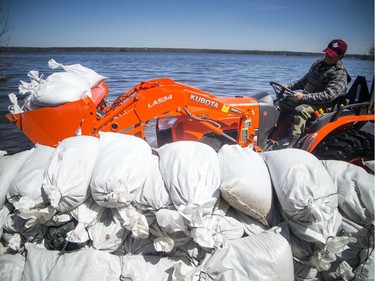 A tractor with a load of sandbags makes its way along the flooded Archibald Street. A state of emergency was declared in Rhoddy's Bay, west of Arnprior, on the Ottawa River Sunday, April 28, 2019.