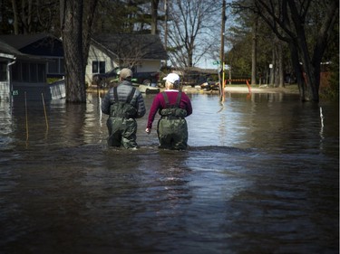 Aiden McGrath and his mom Angie MacCrae walk along in the flood waters, taking a moment away from sandbagging. A state of emergency was declared in Rhoddy's Bay, west of Arnprior, on the Ottawa River Sunday, April 28, 2019.