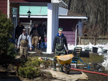 Keaton McGrath brings a wheelbarrow to fill up with more sandbags to continue to build walls to stop the flooding of the family home. A state of emergency was declared in Rhoddy's Bay, west of Arnprior, on the Ottawa River Sunday, April 28, 2019.